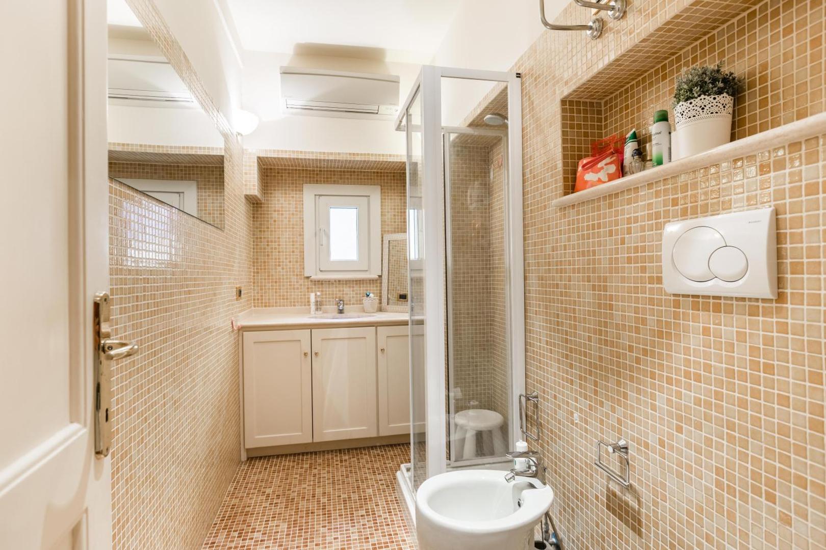 The bathroom, in mosaic tiling, with a walk-in shower